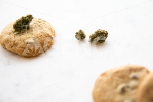 High Angle View on White Marble of Edible Marijuana Chocolate Chip Cookies and Buds - The Cannabiz Agency
