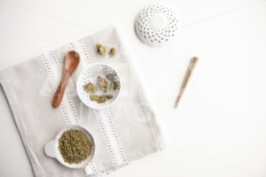 Marijuana Product Laid Out on Clean Place Mat and White Background. Buds, Joint, Flower, Ground Cannabis, Wooden Spoon, Bowl – Minimalist Cannabis - The Cannabiz Agency