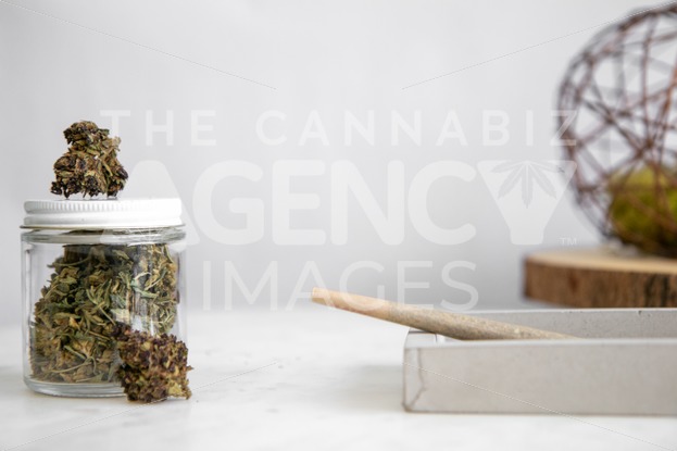 Flower Bud in Glass Jar with Roll on White Marble 3 - Cannabis Royalty Free Stock Images
